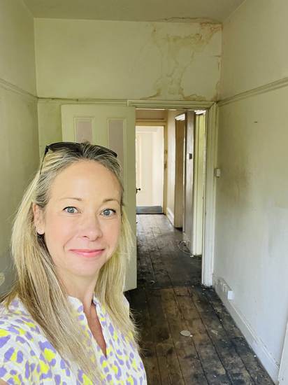 Anna Cooney standing in a derelict, distressed property hallway