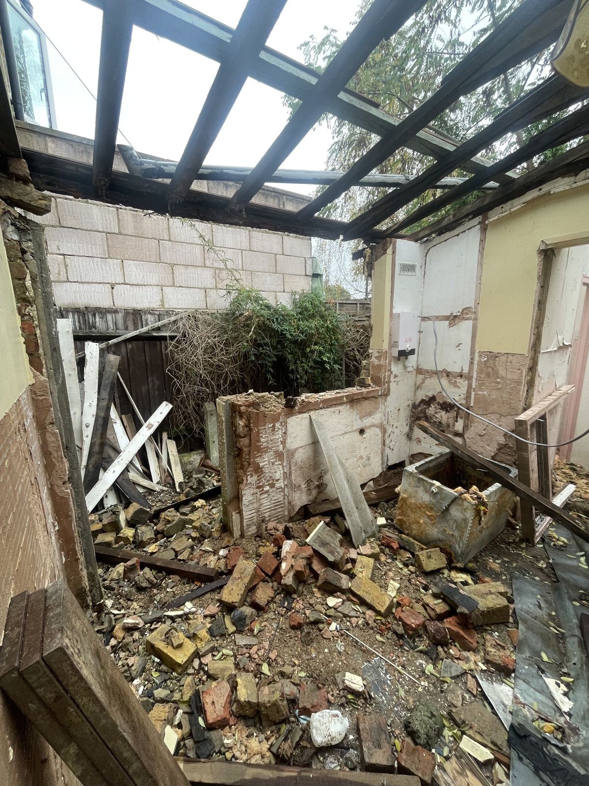 Derelict property mid-strip, exposed brick and roof timbers
